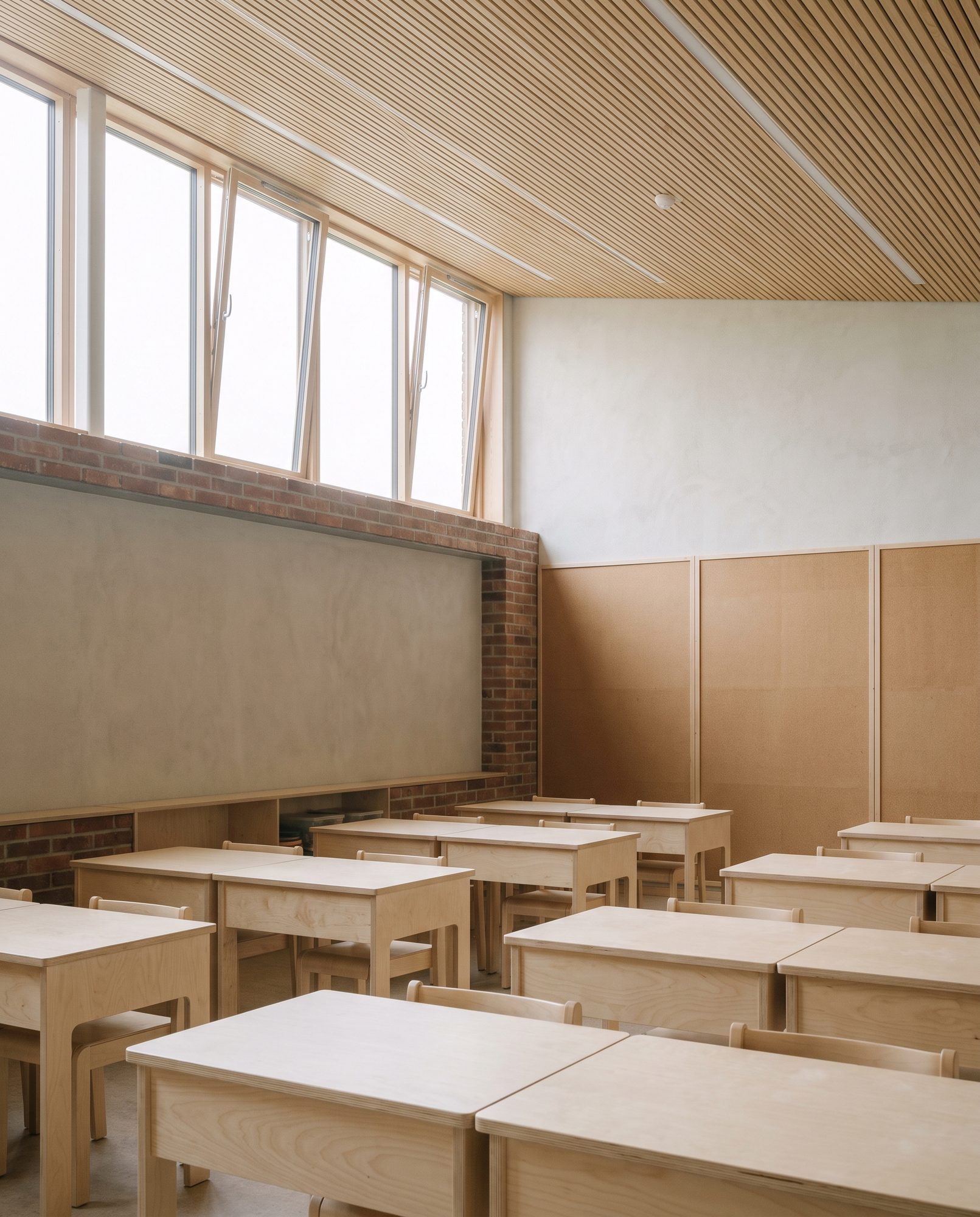 Classroom interior with clerestory daylight and light oak